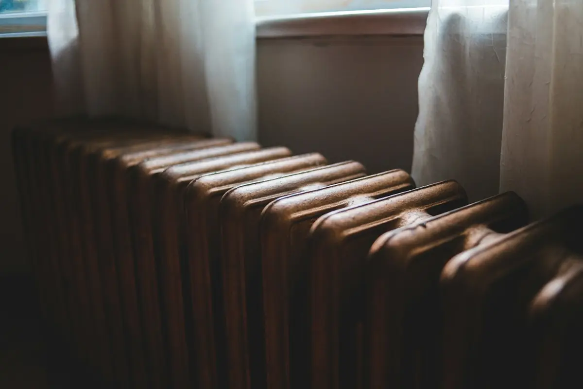 Close view of a cast iron radiator below a window