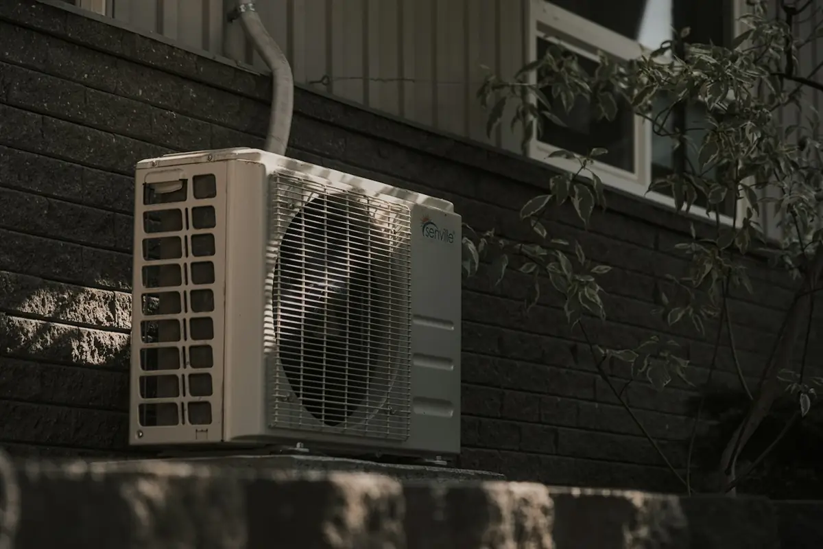 Outdoor air conditioner unit mounted beside a house